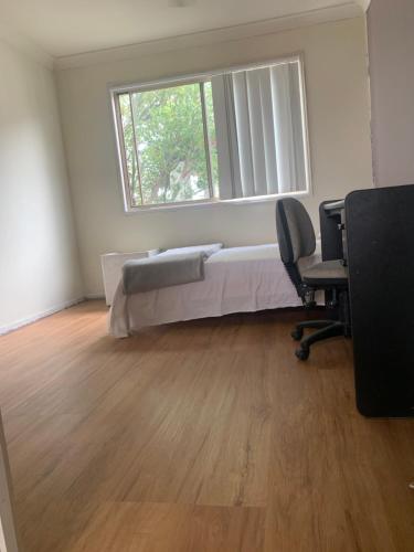 a bedroom with a bed and a window and a desk at Sky BnB room with own bathroom in Gold Coast