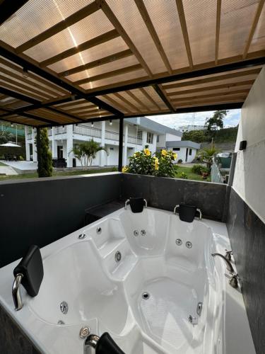 a large white bath tub sitting under a wooden ceiling at Finca hotel nuevo futuro in Luna Park