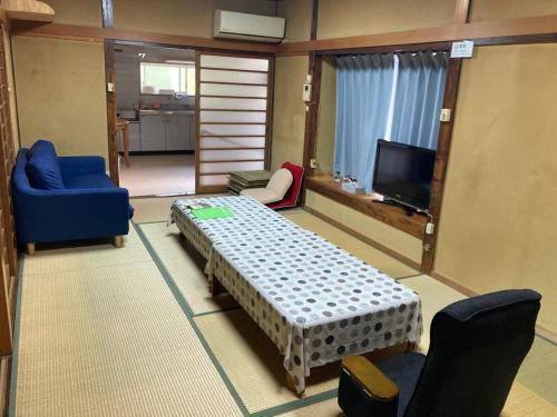 a living room with a table and chairs and a tv at 寺田旅館一軒家レンタル素泊まり最大15人宿泊可能 4名様まで同一料金 in Mine