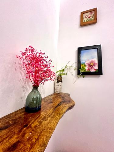 a vase with pink flowers sitting on a table at La Belle An Bang Seaside Hideaway in Hoi An