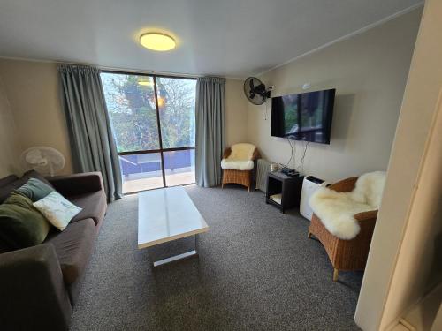 a living room with a couch and a table at Kerikeri Homestead Motel & Apartments in Kerikeri