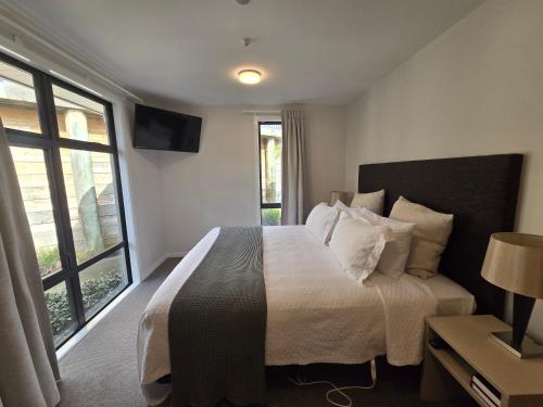 a bedroom with a bed and a large window at Kerikeri Homestead Motel & Apartments in Kerikeri