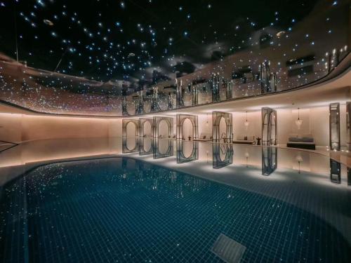 成都市にあるThe Langbo Chengdu, in The Unbound Collection by Hyattの灯り付きの建物内の大型スイミングプール
