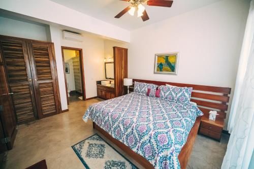 a bedroom with a bed and a ceiling fan at Brahma Blue Resort in San Pedro
