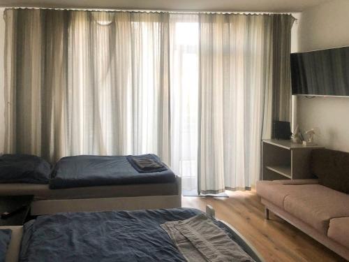 a bedroom with a bed and a couch and a window at Apartment Düsseldorf-Lohausen in Düsseldorf