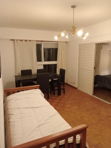 a bedroom with a bed and a table and chairs at Departamento Recoleta Centro in Santa Fe