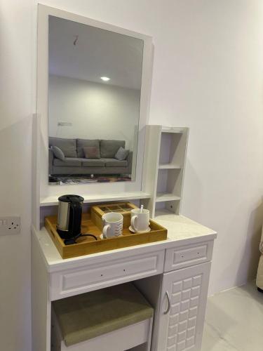 a kitchen counter with two mugs and a mirror at AL- aqyr Rest Garden أستراحة حارة العقر in Nizwa