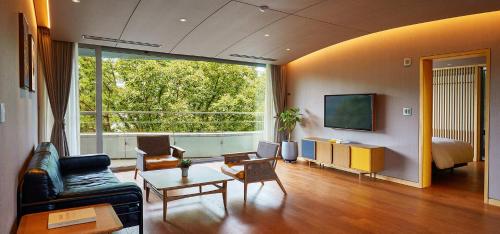 a living room with a couch and a large window at Ananti at Namhae in Namhae