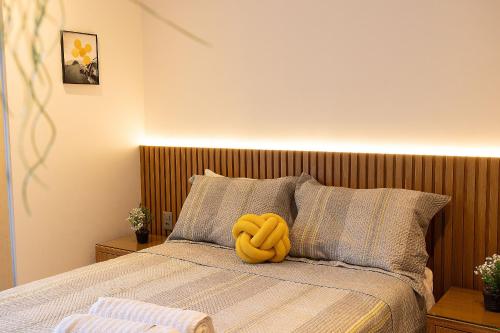a yellow stuffed animal is sitting on a bed at Studio com Varanda a 100 metros da praia in Tambaú