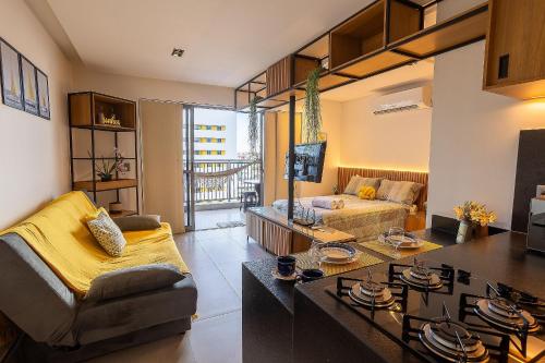 a living room with a couch and a table at Studio com Varanda a 100 metros da praia in Tambaú
