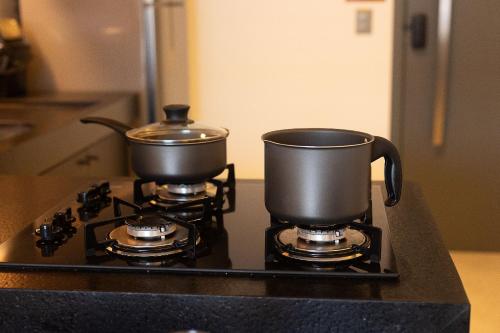 two pots sitting on top of a stove at Studio com Varanda a 100 metros da praia in Tambaú