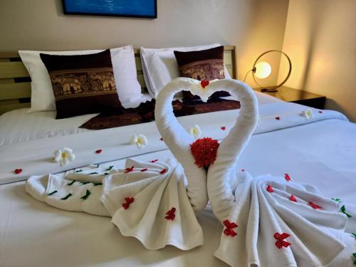 two swans dressed up in towels on a bed at Soleil D'asie Residence in Chaweng Noi Beach