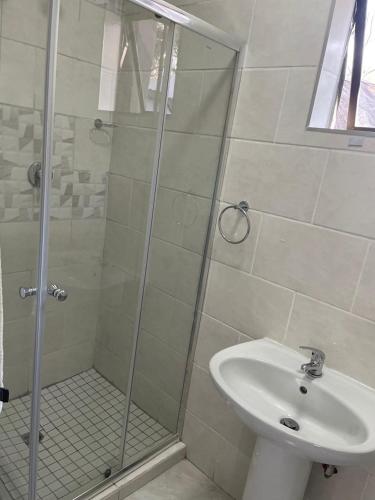 a bathroom with a shower and a sink at SapzRes at Klerksdorp in Klerksdorp