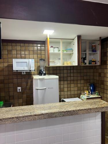 a kitchen with a counter top and a microwave at Pier Sul Apart Service in Salvador