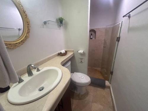 a bathroom with a sink and a toilet and a mirror at Blue angel 20 a pasos de la 5 av in Playa del Carmen