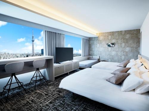 a hotel room with two beds and a television at Lotte City Hotel Kinshicho in Tokyo
