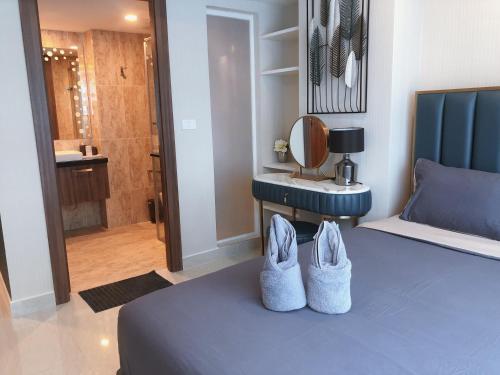 a bedroom with a blue bed with two shoes at Centara Avenue Residence By Daisy Pattaya 1 in Pattaya Central