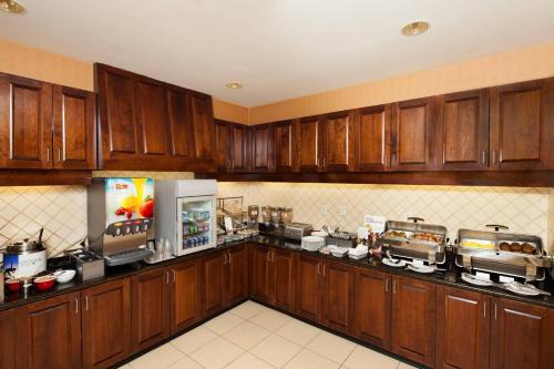 ウィチタにあるResidence Inn by Marriott Wichita East At Plazzioの木製キャビネットと冷蔵庫付きの広いキッチンが備わります。