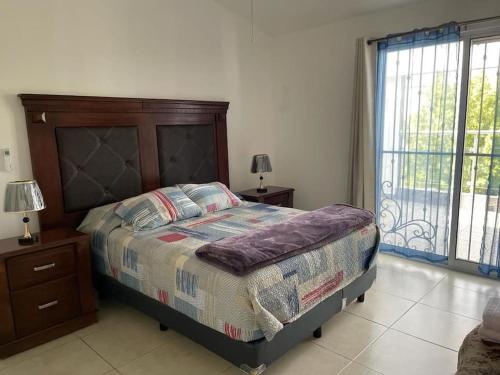 a bedroom with a bed and a large window at bonita casa cerca de la Alameda in Saltillo