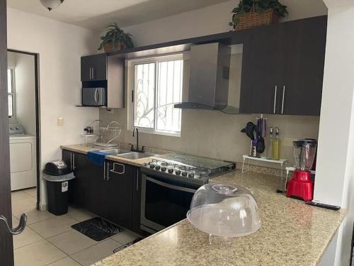 a kitchen with black cabinets and a counter top at bonita casa cerca de la Alameda in Saltillo