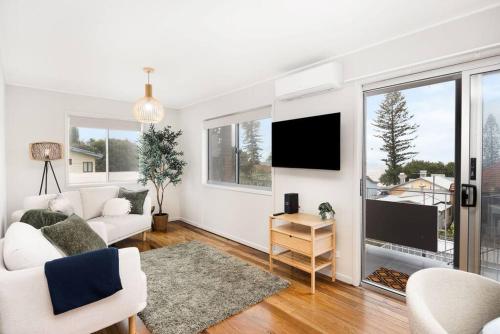 a living room with a couch and a tv at Margate Beach down the lane in Woody Point