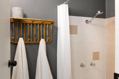 a bathroom with a shower with a white shower curtain at Margate Beach down the lane in Woody Point