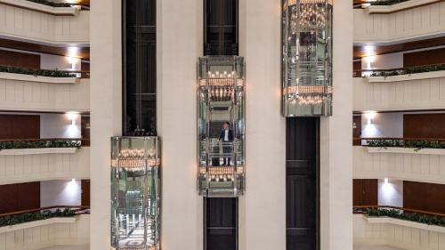 a man in a suit is standing in the middle of a building at Crowne Plaza Bangkok Lumpini Park by IHG in Bangkok