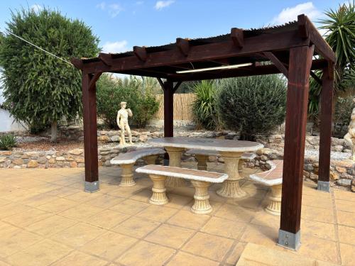 a wooden pergola with a picnic table and benches at Casa Mica in Albox