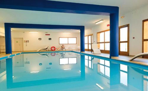 - une grande piscine avec colonnes bleues dans un bâtiment dans l'établissement Appartement Duplex 3 Pièces 6 Personnes MAE-1021, à Le Mélézet