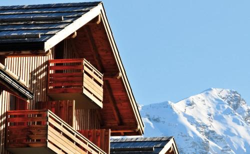 a log cabin with a snow covered mountain in the background at Appartement Duplex 3 Pièces 8 Personnes MAE-1031 in Le Mélézet