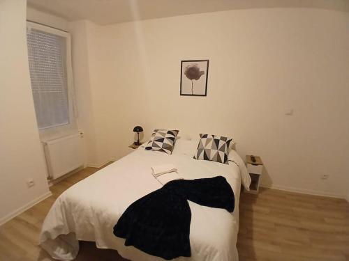 une chambre avec un lit avec une couverture noire et blanche dans l'établissement Appartement F1 orchidée, à Mulhouse