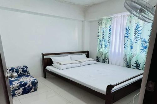 a small bedroom with a bed and a window at Krystal Claine Homestay-BURNHAM HILL in Baguio