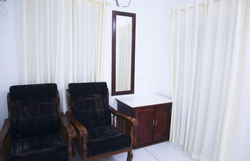 a room with two chairs and a vanity and a mirror at Guestland Homestay in Cochin