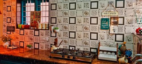 a kitchen counter with a wall covered in pictures at Guestland Homestay in Cochin