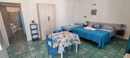 a hotel room with two beds and a table at MAREE SOL RESIDENCE Camere e Appartamenti in Torre San Giovanni Ugento