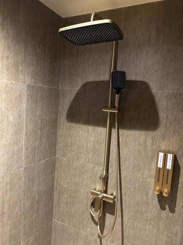 a shower with a shower head in a bathroom at The One Cozy Living in Pattaya