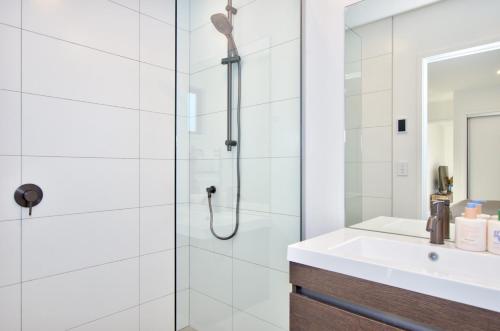 a bathroom with a shower and a white sink at Cosy, Modern Hanley's Farm Unit - Explore Queenstown in Frankton Wharf