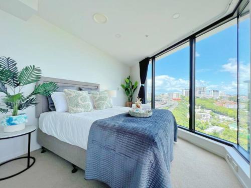 a bedroom with a bed and large windows at Amazing Sunset View Penthouse in Auckland