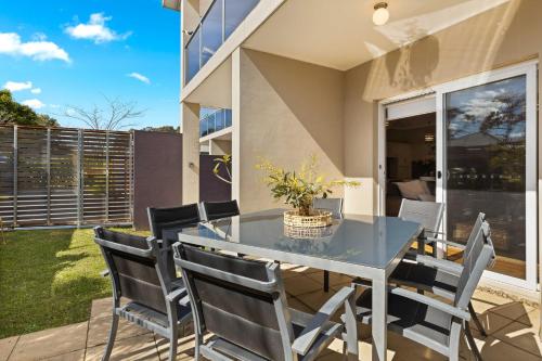 a dining room with a table and chairs on a patio at Husky Haven by Experience Jervis Bay in Huskisson