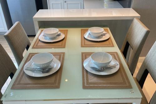 un tavolo con due tazze e piattini sopra di Aqua Resort Phuket - Near Beach and Chalong Pier a Rawai Beach