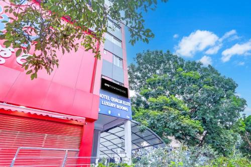 a red building with a sign on the side of it at Super Townhouse QUALIA ELITE S R NAGAR in Hyderabad