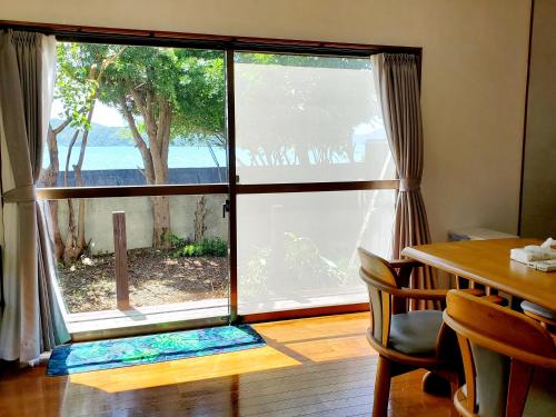 a room with a large window with a view of the ocean at 一棟貸し みじょら しーばなコテージ in Akagina