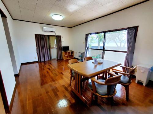 a dining room with a table and chairs at 一棟貸し みじょら しーばなコテージ in Akagina