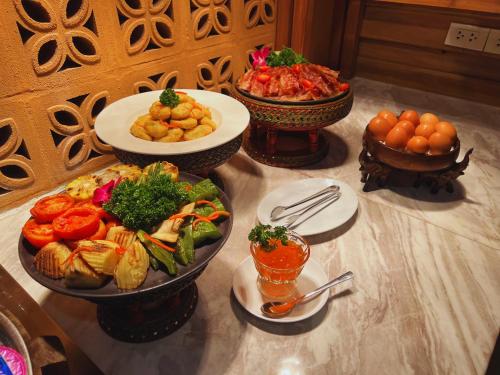 a table with several plates of food on it at Villa Sirilanna Hotel in Chiang Mai
