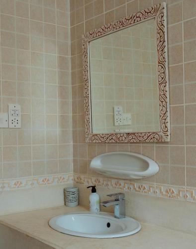 a bathroom with a sink and a mirror at Villa Jasmine - Ocean Front in Bwejuu