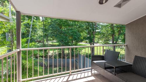 a balcony with two chairs and a table at 9 Reef Terraces Port Douglas in Port Douglas