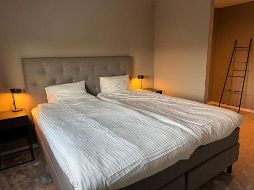 a large bed in a bedroom with two lamps at Boende med närhet till golfbanan i Åhus in Åhus