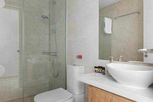 a bathroom with a shower and a toilet and a sink at Serenity Waves Villa 4 in Sophtadhes
