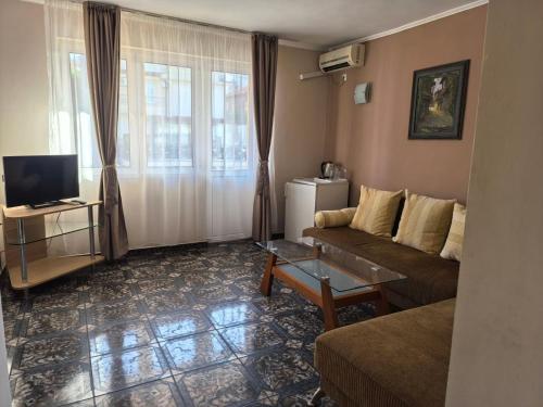 a living room with a couch and a tv at Family Hotel Alfa Vita in Sozopol
