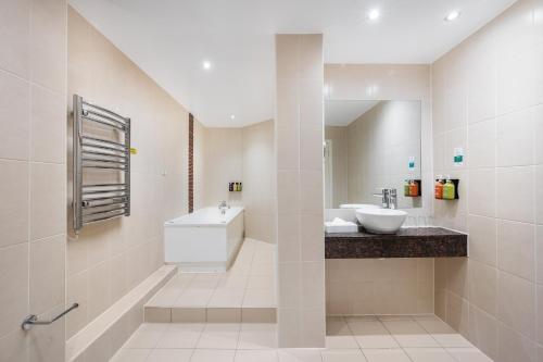 a white bathroom with a sink and a mirror at Holiday Inn Norwich North by IHG in Norwich